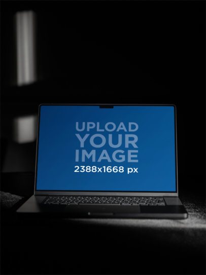 Mockup of a MacBook Placed on a Dark Room