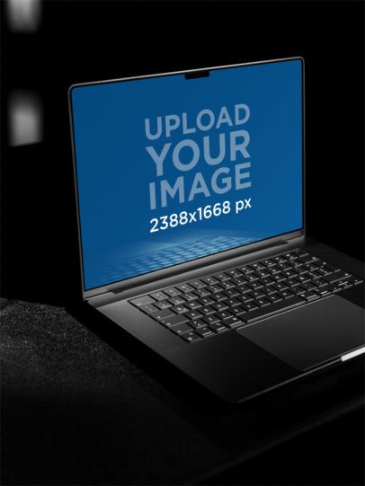 Mockup Featuring an Open MacBook Placed in a Dark Room