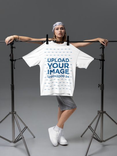 Mockup of a Serious Woman Posing With an Oversized T-Shirt in a Studio m58768