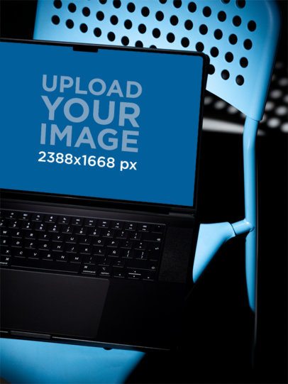 Mockup of an Open MacBook Close-Up on a Blue Chair with Studio Lights