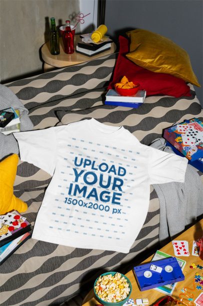 Mockup Featuring an Oversized T-Shirt Lying on a Couch With Snacks and Board Games m58539