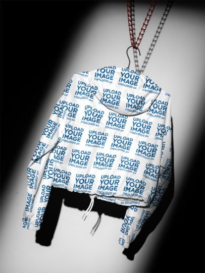 Cropped Hooded Jacket Mockup of a Custom Print Apparel Hanging against a Shadowy Wall