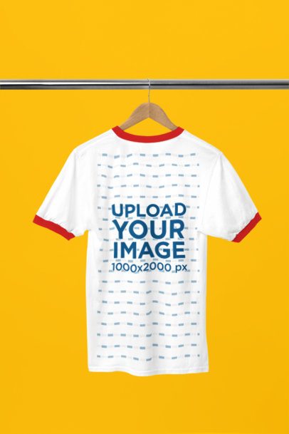 Ringer T Shirt Back Mockup Hanging on a Wooden Hanger Against a Solid Color Background