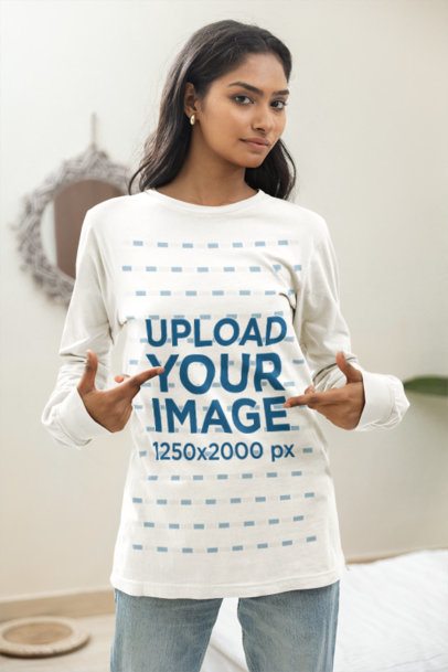 Long Sleeved Tee Mockup of a Woman Gesturing toward Her Apparel inside a Minimalist Room Setting m55401