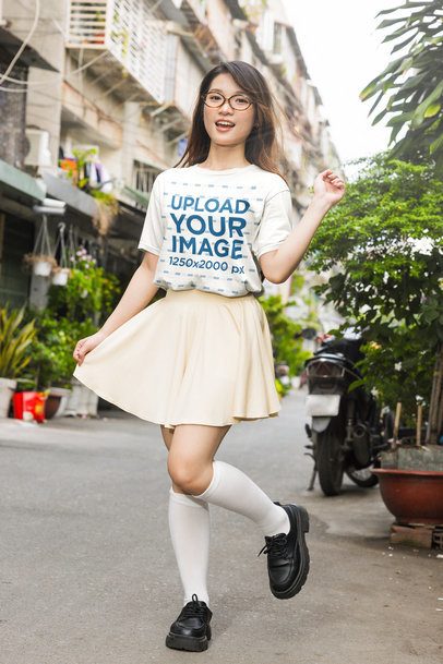 K-Drama T-Shirt Mockup Featuring a Woman Posing on an Urban Street m55320