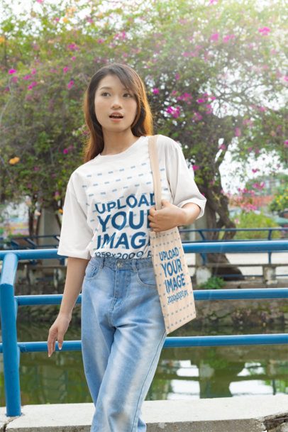 K-Drama T-Shirt and Tote Bag Mockup Featuring a Woman Outdoors m55310