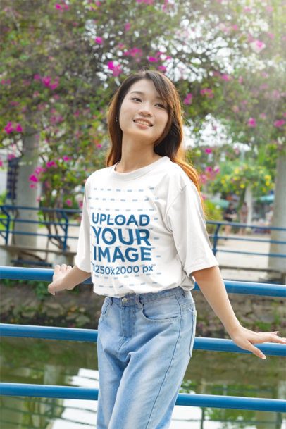 K-Drama T-Shirt Mockup Featuring a Woman Posing at a Park m55309