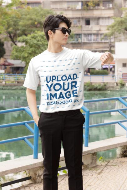 T-Shirt Mockup featuring a Cool Young Man in Sunglasses Checking His Watch with a K-Drama Vibe by an Outdoor Pond m55304