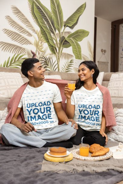 Couple T Shirt Mockup with a Man and Woman looking at Each Other during a Picnic at Home m55415