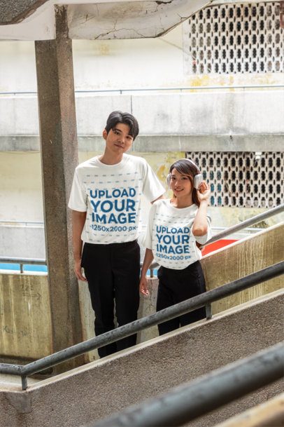 K-Drama Couple T-Shirt Mockup featuring a Man and Woman on a Concrete Staircase m55294