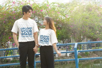 T-Shirt Mockup featuring a Young Couple Holding Hands with K Drama Vibe in a Floral Park