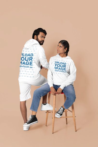 Matching Hoodie Mockup Featuring a Man Looking Over His Shoulder and a Woman Sitting on a Stool in a Studio m51820