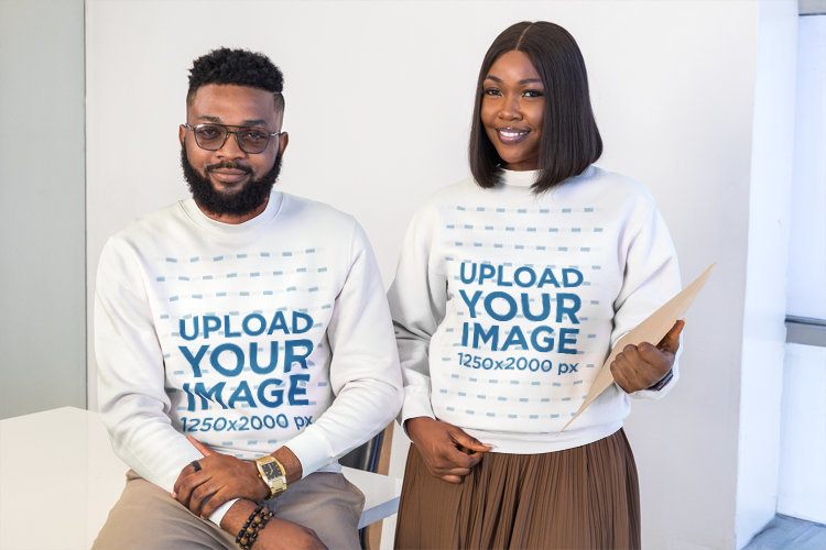 Corporate Sweatshirt Mockup Featuring a Black Man and Woman Posing Together in a Bright Office