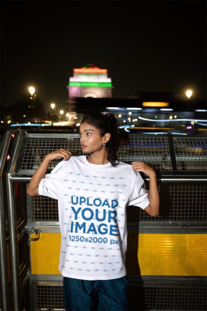 Oversized T-Shirt Mockup of a Woman Adjusting Her Shirt on a City Street at Night m56838