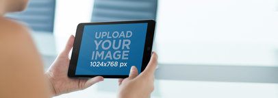 Mockup of a Young Woman Using a Black iPad Mini at Home