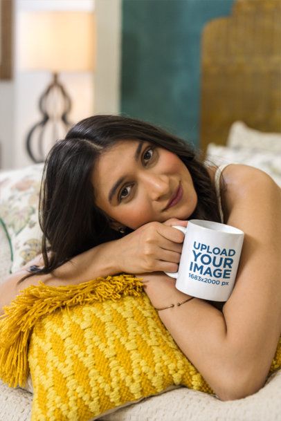 Mug Mockup Featuring a Relaxed Woman Resting on a Yellow Pillow Enjoying