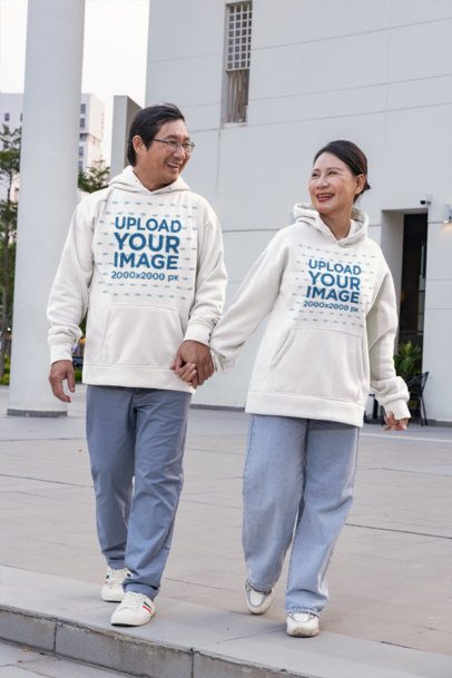 Hoodie Mockup Featuring a Smiling Older Couple Holding Hands and Walking in an Urban Plaza m55964