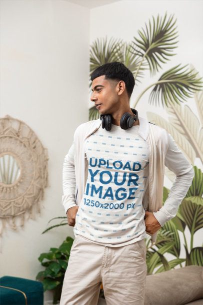 Mockup of a Man Wearing a Sweartshirt With Headphones Around His Neck Standing Indoors