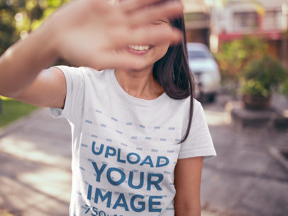 T-Shirt Mockup of a Happy Girl Blocking the Camera with her Hand 20567