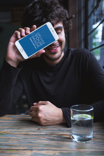 iPhone Mockup of a Man Covering his Face at a Restaurant