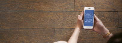 Mockup Template of a Lady Using a White iPhone Over a Wooden Floor