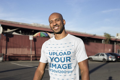 Mockup of a Smiling Man Wearing a Tshirt at a Parking Lot