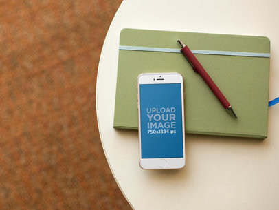 White iPhone 6 Mockup on a Table With a Notebook 