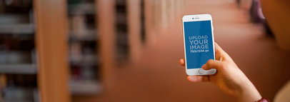Mockup of a Woman at the Library Hall Using an iPhone 6