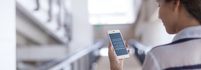 Mockup Template of a Woman Using an iPhone 6 at the University