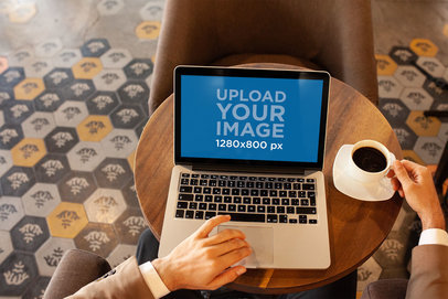 Mockup of a Businessman Using a MacBook at a Cafe