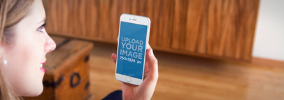 Mockup of a Woman Using a White iPhone 6 in her Living Room