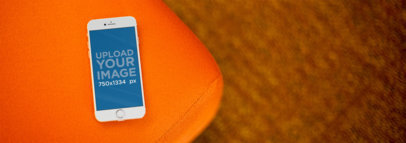 Beautiful Mockup of a White iPhone 6 Over Orange Sofa