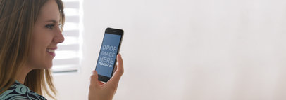 Mockup Template of a Young Woman Looking at Her iPhone