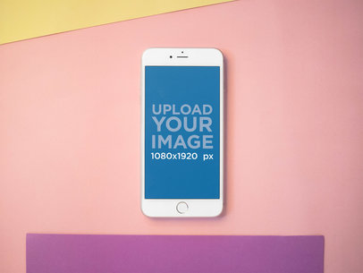 Mockup of an iPhone Lying on a Pink Surface with Purple and Yellow