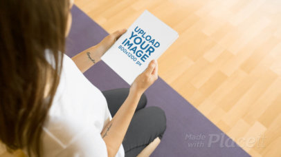 Young Woman Doing Yoga While on an Empty Room with a Book Lying Close to Her Template Video