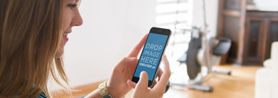 Mockup Template of Young Woman Holding iPhone 6 at the Living Room