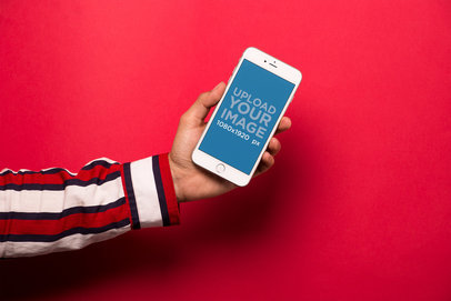 Mockup of an iPhone Held Against a Red Wall