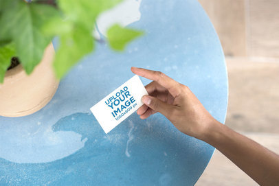 Mockup of a Business Card Being Held Next to a Plant Pot