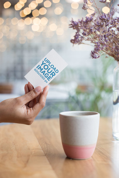 Mockup of a Vertical Business Card Held on a Coffee Table