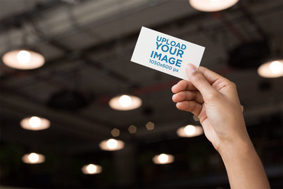 Mockup of a Business Card Being Held Against a Roof