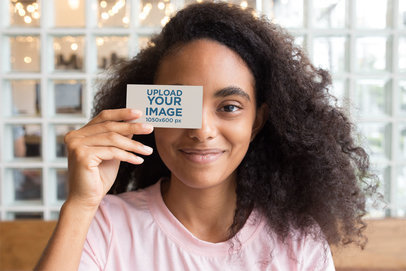 Mockup of a Woman Holding a Business Card Against her Face