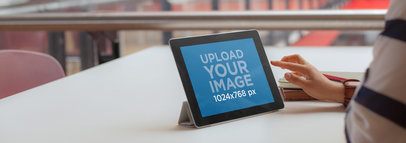 iPad Mockup Featuring a Young Woman at a Table