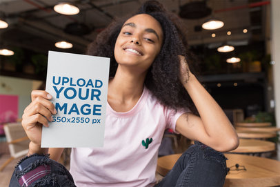 Mockup of a Smiling Woman Holding a Flyer