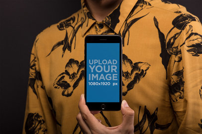 Mockup of a Man Holding a Space Gray iPhone 8 Plus Against his Light Orange Shirt 21778