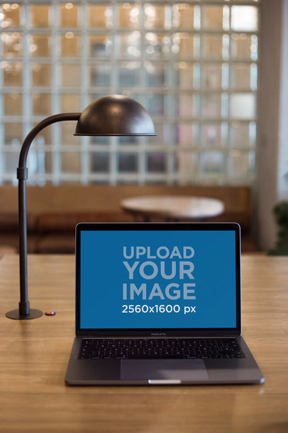 MacBook Mockup on a Wooden Table Next to a Lamp 21623