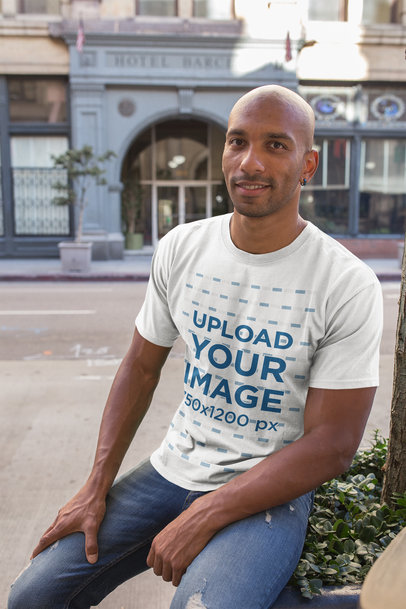 T-Shirt Mockup of a Man Casually Sitting on a Street Planter 18232