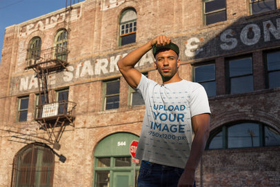 T-Shirt Mockup of a Man Standing in Front of an Old Brick Building 18318