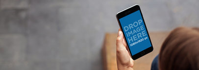 Black iPhone 6 Mockup Featuring a Woman Sitting on a Staircase