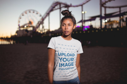 Tshirt Mockup of a Girl with a Messy Bun Posing at an Amusement Park at Night 18328