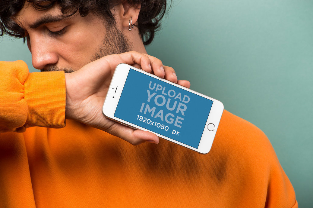 Mockup of an iPhone 8 Plus Held by a Man in Front of a Cyan Background